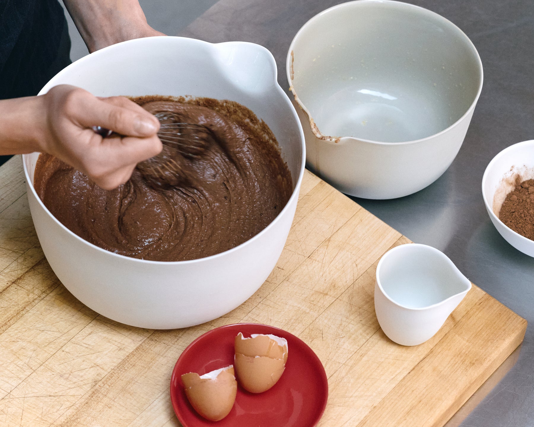 Chocolate and almond pudding batter being whisked in a mixing bowl