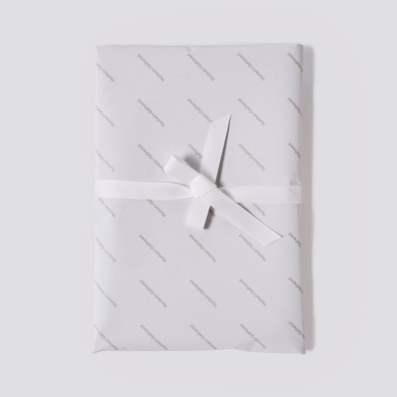 Overhead view of a Hunted+Gathered gift box with a white ribbon
